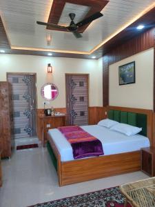 1 dormitorio con 1 cama y ventilador de techo en Kaafal hotel & restaurant, en Dhanaulti