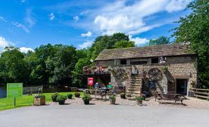 a stone building with people sitting outside of it at Sunflower Lodge, Lido Leisure Park, Knaresborough in Knaresborough