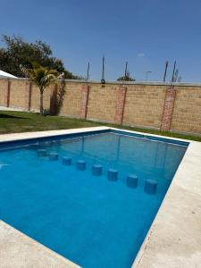 uma grande piscina azul com cadeiras em Casa ventanales em Chiconcuac