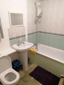 a bathroom with a sink and a toilet and a tub at Beautiful and peaceful large double bedroom near Olympic Park in Stratford London in London