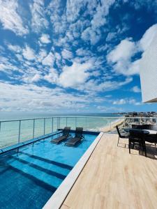 a pool on the roof of a building with a view of the ocean at RN Studio Maceió Apto 302 in Maceió
