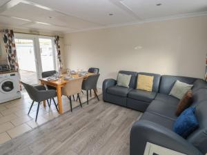 ein Wohnzimmer mit Sofa und Tisch in der Unterkunft Barn Cottage in Laugharne + 11 Fotos