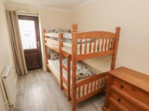 ローアーンにあるBarn Cottageのベッドルーム1室(二段ベッド2台、窓付)が備わります。