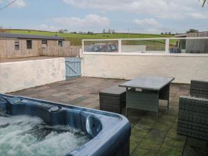 ein Wasserbad mit einem Tisch und einem Tisch in der Unterkunft Barn Cottage in Laugharne