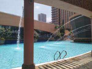 a swimming pool with a fountain in a city at Times Square Service Suites Kuala Lumpur in Kuala Lumpur