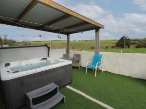 een hot tub op een gazon met een blauwe stoel bij Meadow View in Laugharne