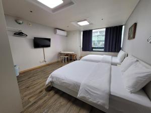 una camera d'albergo con due letti e una televisione di SHseoul a Seul