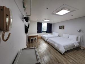 a hotel room with two beds and a phone at SHseoul in Seoul