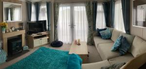 sala de estar con sofá y TV en Sunflower Lodge, Lido Leisure Park, Knaresborough, en Knaresborough