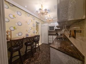 a kitchen with a counter and some stools in it at Botanical Garden Vacation House in Liwa