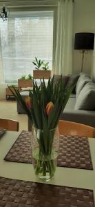 Un jarrón de flores sobre una mesa en una sala de estar. en Pikiruukin helmi, en Kokkola