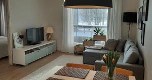 sala de estar con sofá y TV en Pikiruukin helmi, en Kokkola