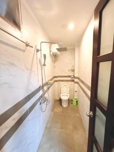 een kleine badkamer met een toilet en een deur bij Kenzi Homestay - có cho thuê xe gắn máy, xe đạp in Hue