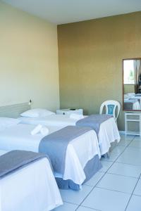 a group of three beds in a room at Pousada Aeroporto in Parnaíba