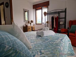 a bedroom with a bed with towels on it at Vivienda Vacacional La Escribana - Casas de los Picos in El Mazo