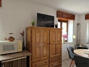 a television on top of a wooden cabinet with a microwave at Vivienda Vacacional La Escribana - Casas de los Picos in El Mazo