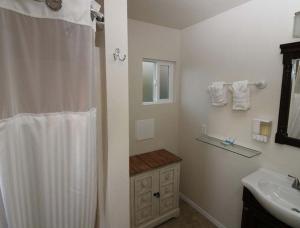 a bathroom with a shower curtain and a sink at Back Bay Inn in San Luis Obispo