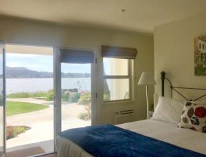 a bedroom with a bed and a view of the water at Back Bay Inn in San Luis Obispo