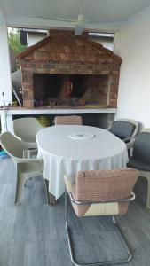een witte tafel en stoelen voor een open haard bij Kuća za odmor Drina in Zvornik