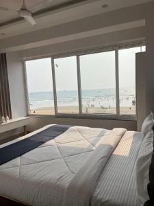 Baga beach front في باغا: غرفة نوم بسرير وإطلالة على الشاطئ