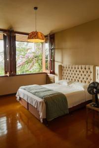 um quarto com uma cama e uma grande janela em Casa Pinheiral em Bragança Paulista