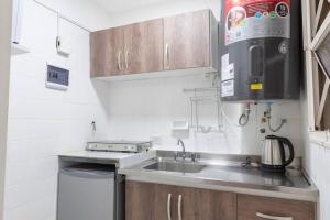 Una pequeña cocina con fregadero y microondas. en Cañitas Chic, en Buenos Aires