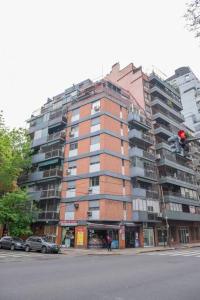 un edificio alto con un semáforo rojo delante de él en Cañitas Chic, en Buenos Aires