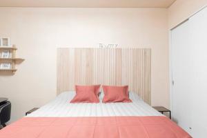 um quarto com uma cama com duas almofadas cor-de-rosa em Cañitas Chic em Buenos Aires