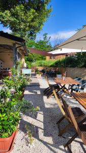 un patio con mesas de madera, sillas y plantas en Camping Le Marche Apartments, en Gualdo di Macerata