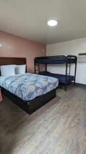 een slaapkamer met 2 stapelbedden en een houten vloer bij Portland Value Inn in Portland