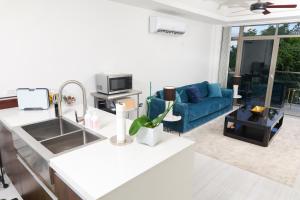 a kitchen and living room with a blue couch at Bella Studio Apartments - Lux Loft in Kingston