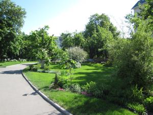 einem Park mit grünem Gras und Bäumen und einem Bürgersteig in der Unterkunft Cherkasy Palace in Tscherkassy