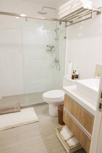 uma casa de banho com um chuveiro, um WC e um lavatório. em Bella Studio Apartments - Lux Loft em Kingston