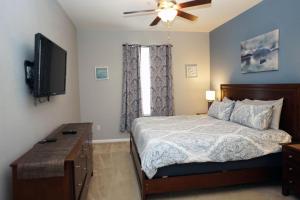 um quarto com uma cama e uma televisão de ecrã plano em WH205B 3 BR Windsor Hills Condo! em Orlando