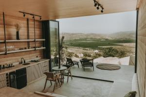 eine Küche mit einer Terrasse mit einem Tisch und Stühlen in der Unterkunft MIRA Earth Studios in San Antonio de las Minas