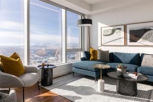 a living room with a blue couch and windows at Award winning 1 bedroom apartment - extended stay in Calgary