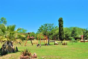 un parc avec une balançoire et une aire de jeux dans l'établissement Keantúpa Cabañas, à San Marcos Sierras