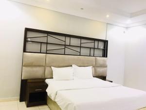 1 dormitorio con 1 cama grande con sábanas blancas en راسيات الحمدانية - Hotel Rasiyat en Yeda