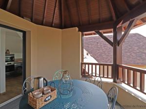 a dining room with a blue table and a balcony at Maison moderne avec jardin clos et SPA privatif en Normandie - FR-1-497-189 in Athis