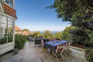 Un patio con una mesa y sillas en un balcón. en Bay House, en Seaview