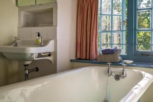y baño con bañera y lavamanos. en Bay House, en Seaview 49 fotos más