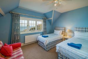 Un dormitorio con dos camas y una ventana. en Bay House, en Seaview