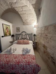 een slaapkamer met een bed in een stenen muur bij La Maison di Paola in Ostuni