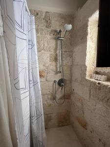een badkamer met een douche en een douchegordijn bij La Maison di Paola in Ostuni