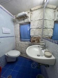 een badkamer met een witte wastafel en een toilet bij La Maison di Paola in Ostuni