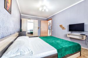 een slaapkamer met een groot bed en een flatscreen-tv bij Квартира в престижном районе в новостройке in Pavlodar