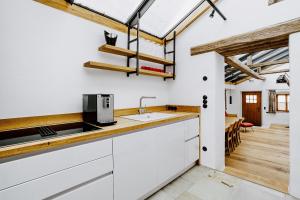 a kitchen with white cabinets and a sink and a dining room at Jura-Chalet in Riedenburg