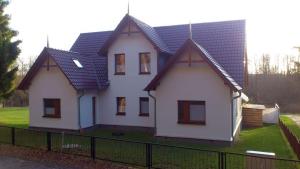 een groot wit huis met een zwart dak bij Ückeritz, Villa Wald-Eck - Erdgeschoss in Ueckeritz