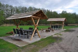 een groep tafels en stoelen onder een houten paraplu bij Ückeritz, Villa Wald-Eck - Erdgeschoss in Ueckeritz +16 foto's