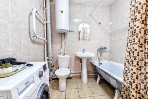 een badkamer met een toilet, een wastafel en een bad bij Квартира в престижном районе в новостройке in Pavlodar